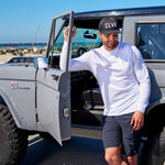Man standing next to vintage truck wearing Black Clover Live Lucky CLVR hat in black.